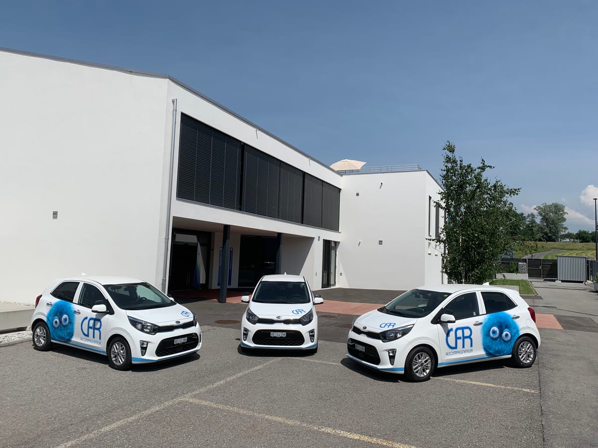 Le bâtiment principal du Centre de formation routière de Savigny, avec trois voitures de l'école devant l'entrée